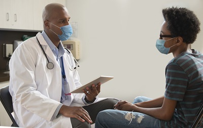 male doctor talking with male teen